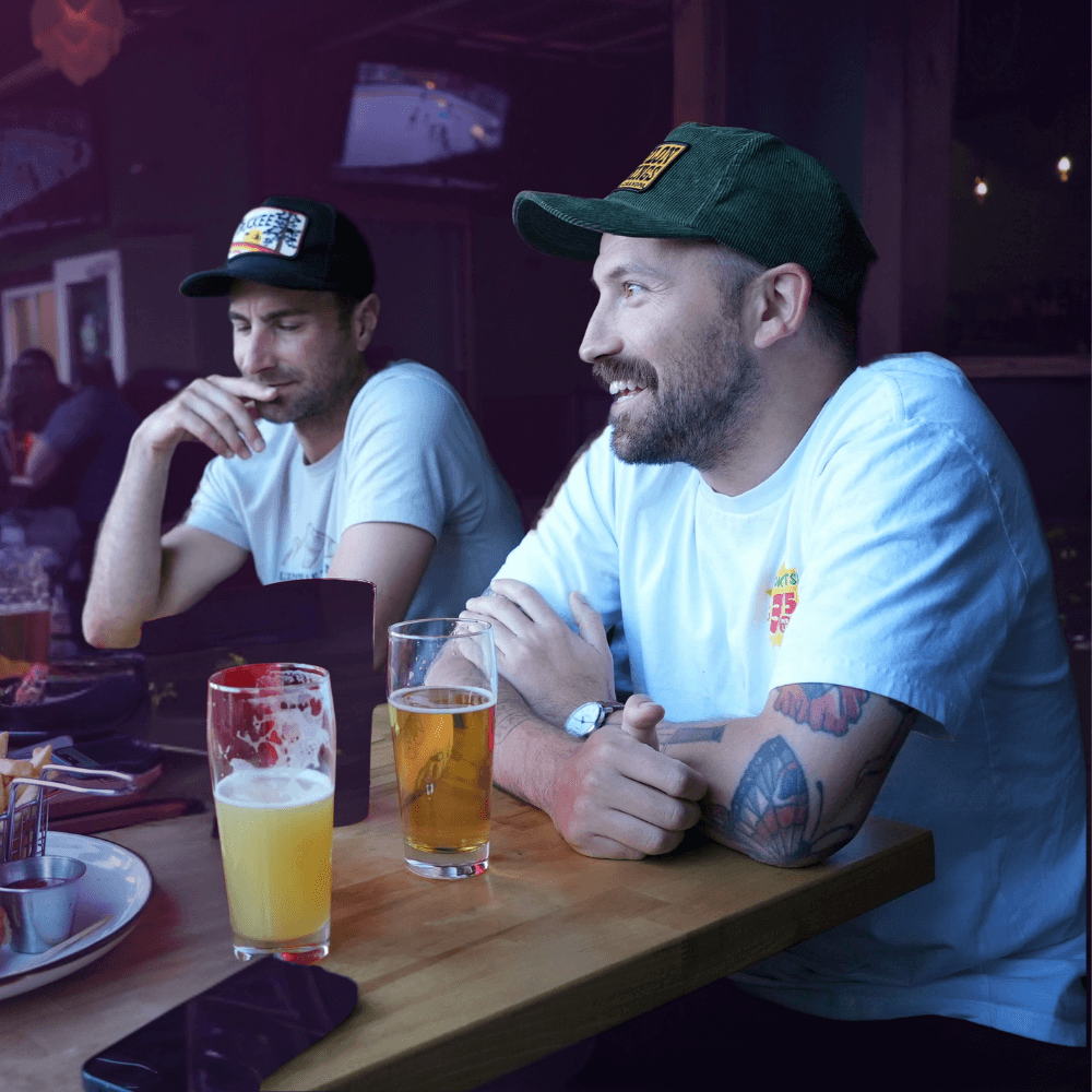 Don’t Make These 10 Trivia Night Mistakes at Your Bar 3 Two men enjoying drinks at a Portland bar during a Last Call Music Bingo night—relaxed atmosphere, full seats